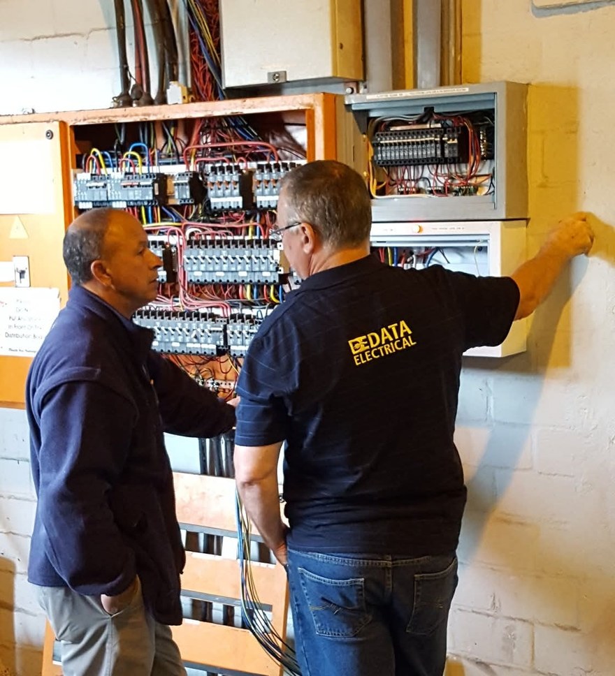Data Electrical technicians working at an electrical distribution board